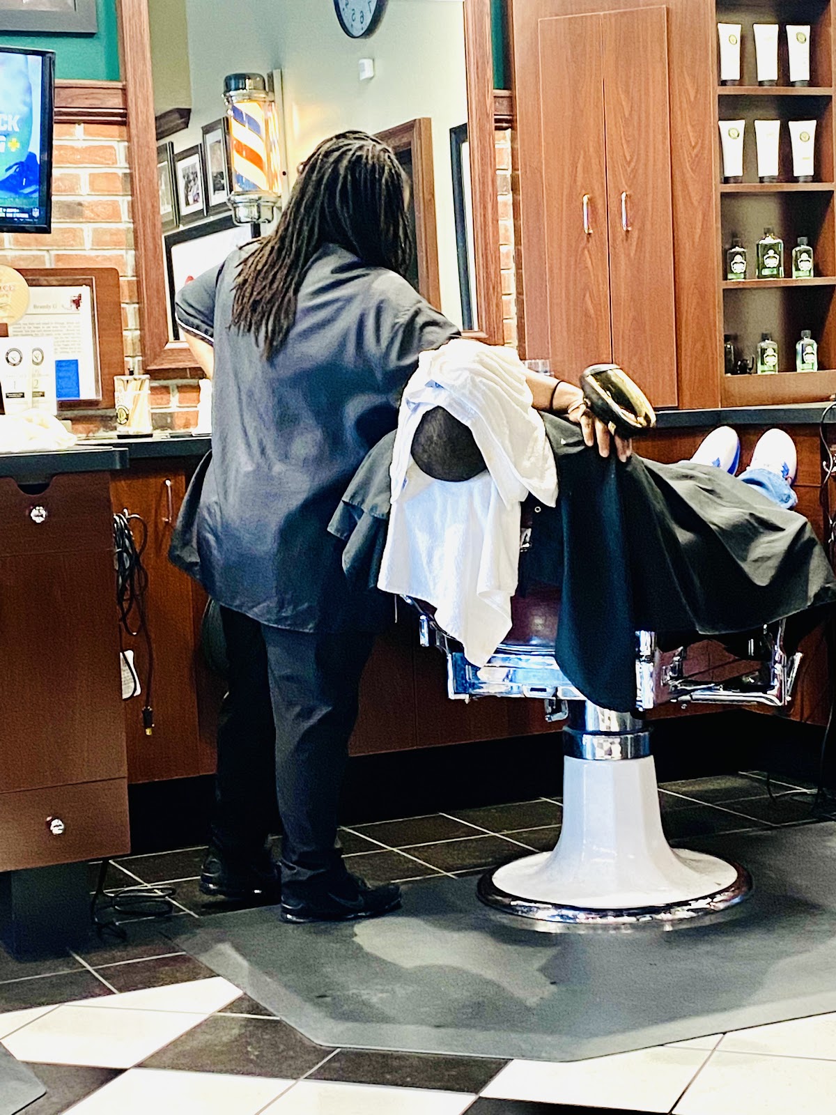 Barber preparing shave service with grooming products on shelf