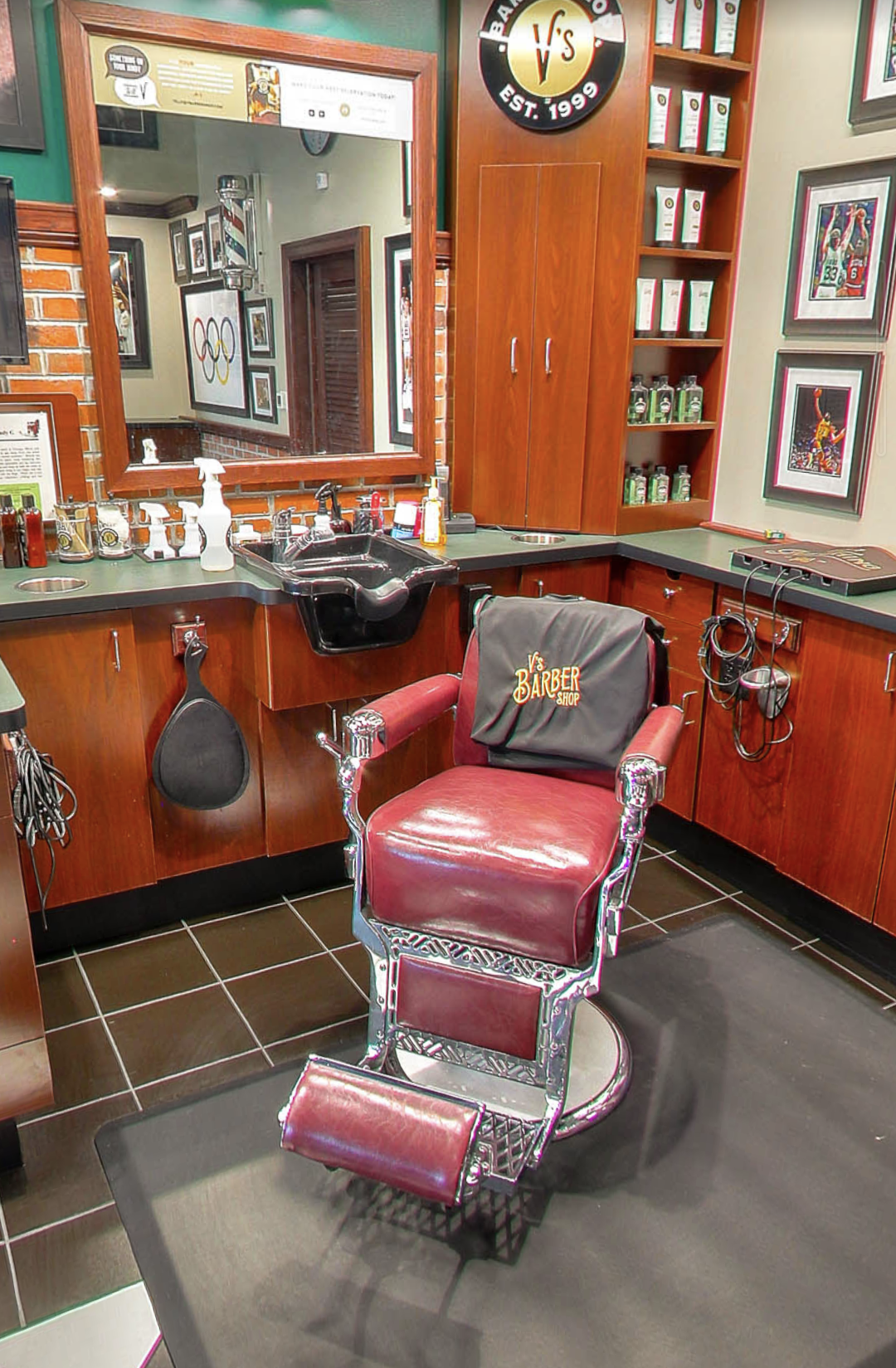 Classic red leather barber chair with V's Barbershop branding